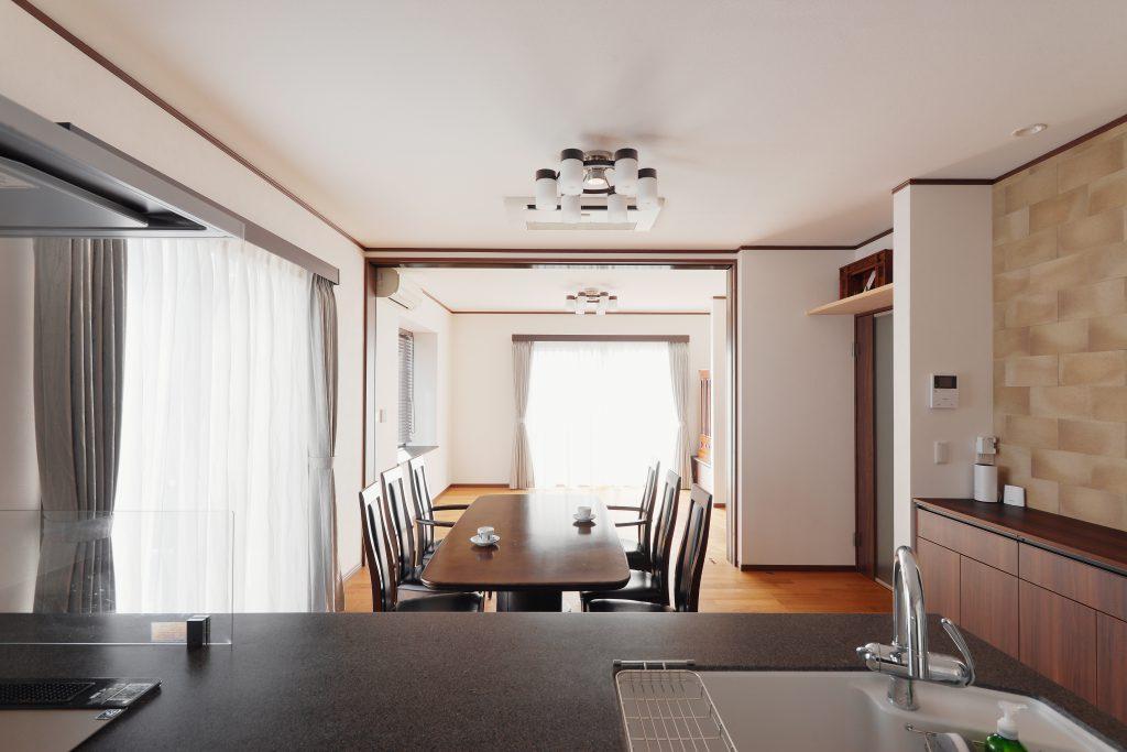 キッチンに立つと視界が広がるLDK 。ダイニングテーブルの奥に広がるリビングは可動の間仕切りで仕切ることもできます。