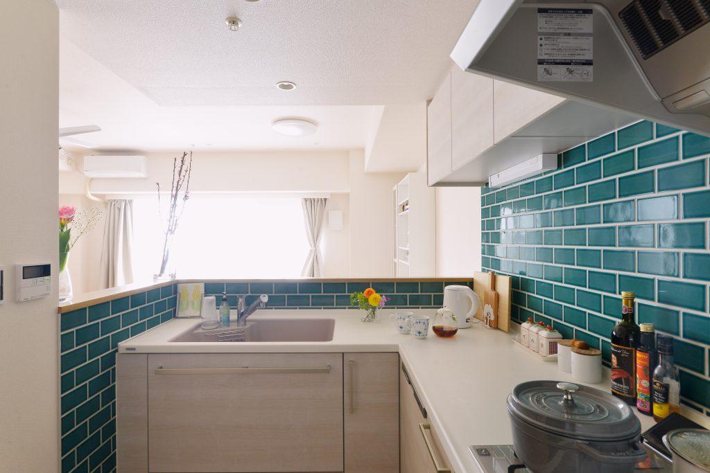 絶妙な色合いのタイルを貼ってカフェの様な雰囲気のキッチン。他社にできないと言われたという対面キッチンはPSの検証をした上でL型キッチンの向きを逆にして実現。