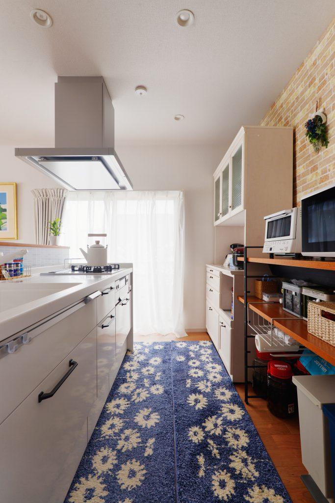 キッチン背面は圧迫感のない収納。調理家電やごみ箱まですっきり納まります。お手持ちの籠類なども活用できる「自分仕様」です。