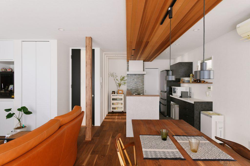 キッチンからダイニングにかけての天井には無垢のウッドパネルを貼って広がり感を強調。ダイニングテーブルはウォルナット材の無垢天板を取り寄せた特注品。