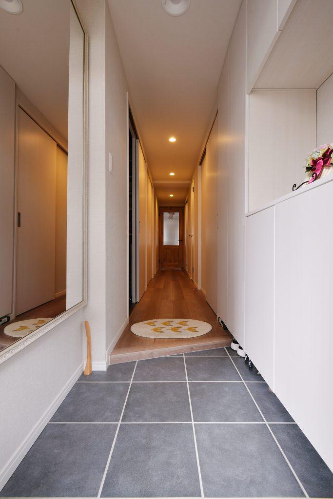 玄関框は斜めにきって奥行き感を強調。浮かせた収納の下に脱いだ靴をさっと格納すれば玄関はいつでもすっきり！