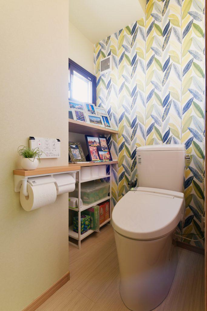 1階トイレは向きを変えることで棚スペースを確保。小物や写真を飾って楽しめるようになりました。