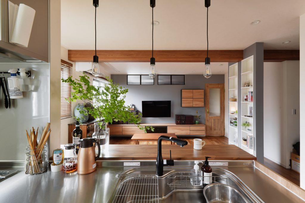 お洒落なカフェにいるようなリビング空間。眺めの良いキッチンは「居たくなる空間」です。ブラック水栓とペンタント照明の黒が効いています。