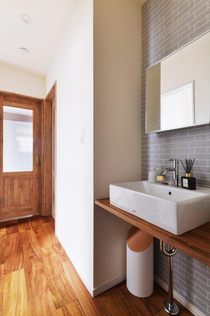 階段を上がりきったところに手洗いを設けました。目につく場所なのでアクセントクロスで上品に仕上げました。