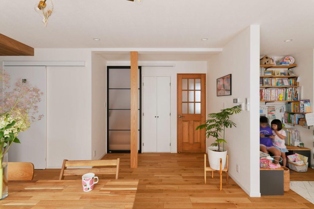 構造上抜けない柱はあえて木目で強調してシンボルにしています。階段下にアウトセット引戸を付けることで冷暖房効率をアップ。ほんのり向こう側が見える建具にすることで意匠性も安全性も兼ね備えています。