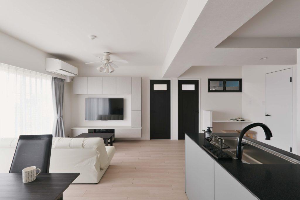 キッチンの天板と水栓は黒。スタイリッシュな空間になりました。写真正面の二つのドアはリビングから出入りできる子ども部屋。右側のお部屋には窓がないために室内窓をつけています。