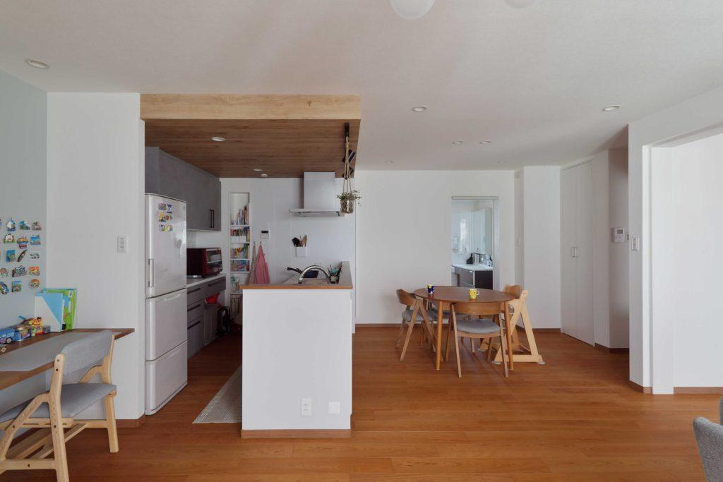 キッチン上の天井を下げてダウンライトを仕込んだり、レンジフードのダクトを隠しています。敢えて木目のクロスで仕上げて強調することで、キッチン周りの雰囲気もアップ。