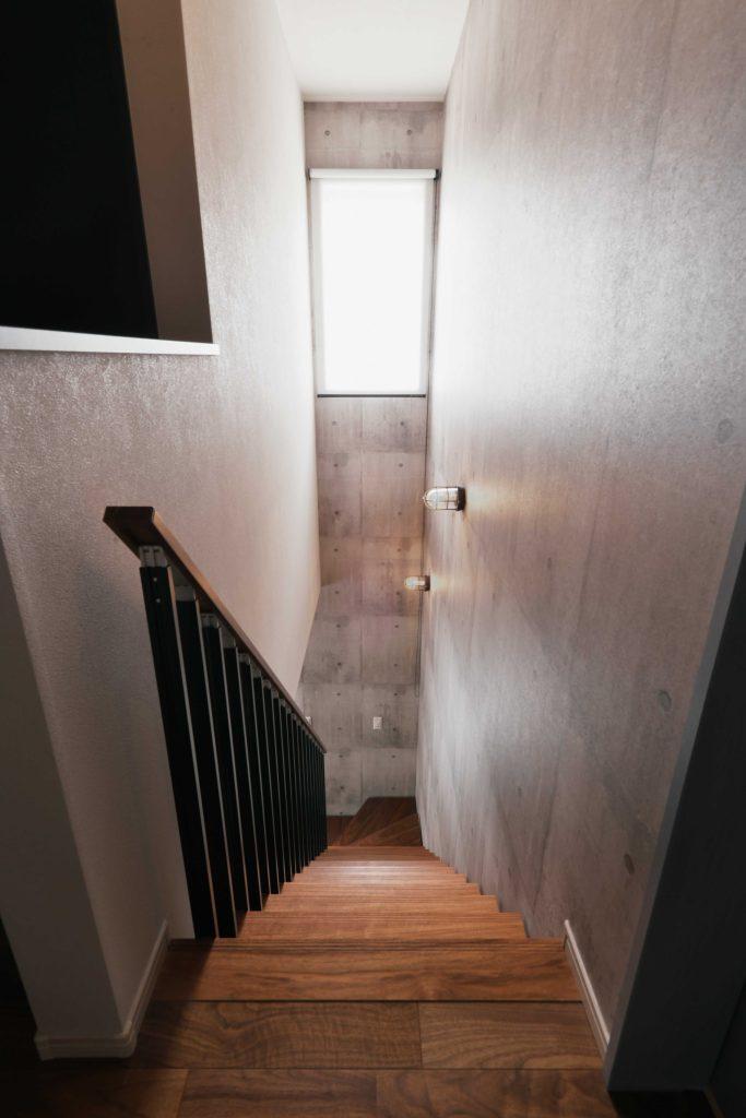 石目調のクロスで仕上げた階段。手すりのデザインにもこだわりました。