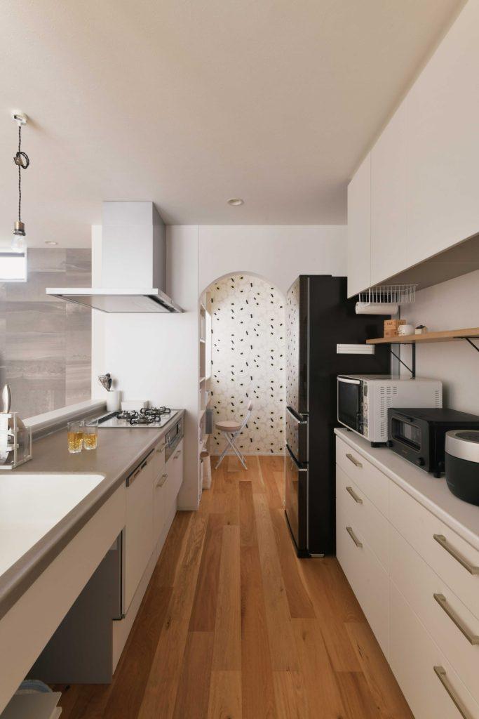 キッチンの奥はパントリー。マリメッコ柄のアクセントクロスとアーチの開口部が楽しい雰囲気に。キッチンに立つのも楽しくなりそうです。