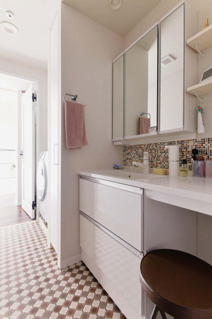 鏡下のアクセントタイルや タイル風のクッションフロア床で可愛い雰囲気の洗面室です。