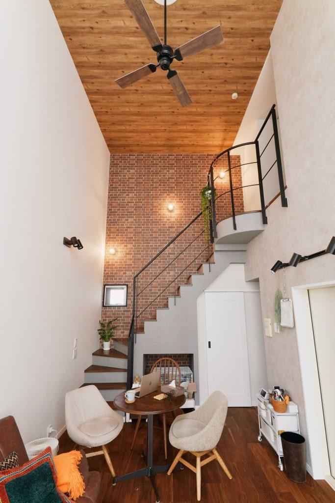 階段は打ちっぱなしコンクリート調とレンガ調のクロスを組み合わせて印象的な雰囲気に。ななめに配置したマリンライトも効いています。