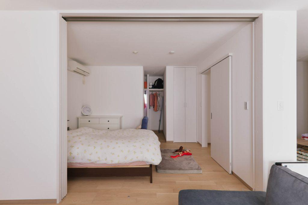 リビング隣の寝室は可動の間仕切りで可変的に過ごせます。寝室奥には大きなWICも設けました。