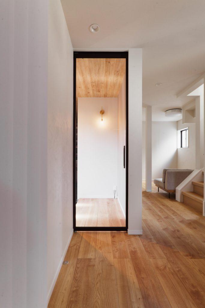 こちらはゲスト用リビングドア。薄いフレームで高さのあるドアで高級感を演出しています。