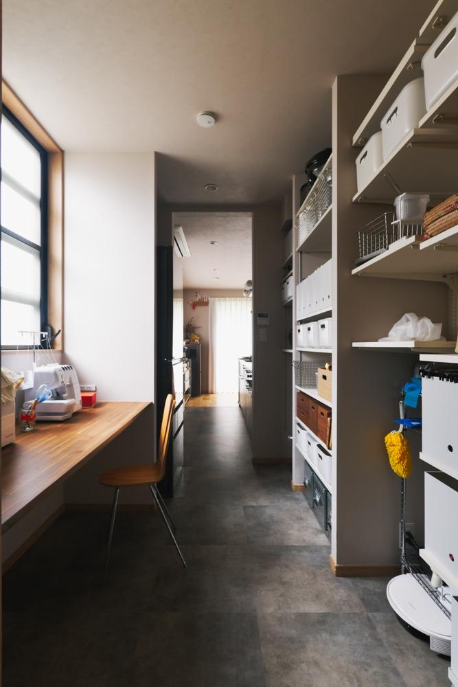 パントリーの一角には趣味のミシンコーナーを組み込みました。ミシン台になるカウンターデスクの奥を切り欠いて自然と布が下に送られるように加工しました。