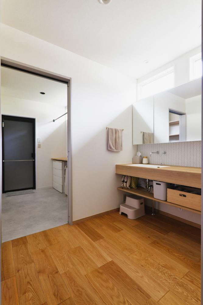 タイルで仕上げた造作洗面台と、隣は脱衣室兼ランドリールーム。広々空間を確保しているからストレスなく家事ができます。