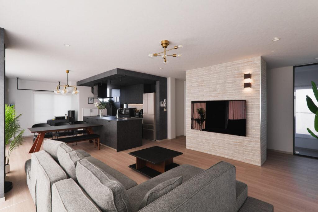 TVをかけている壁を新たに造作。裏側はAV機器の配線を兼ねた収納を組み込みました。大きな柱のように塊で見せたいという意図でエコカラットと間接照明で視線を集めるお洒落なアクセントとして仕上げ、壁の裏側も通路として通りぬけられるようになっているのでTV鑑賞中に前を横切らなくても済むように配慮しました。