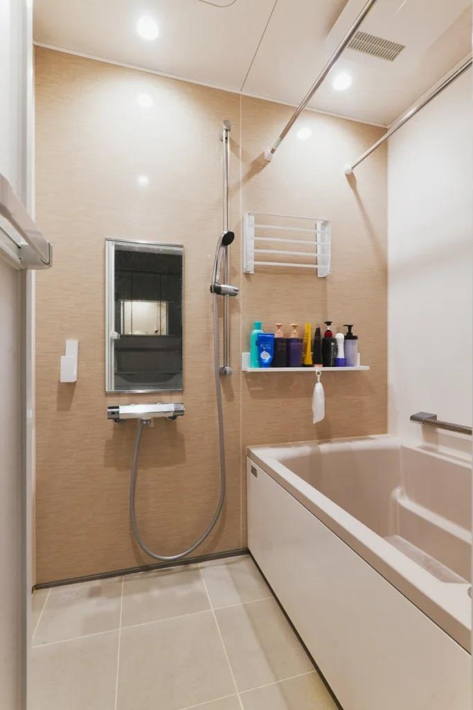 アクセントパネルで雰囲気にもこだわった浴室。トイレは縦管を壁で多いアクセントクロスや棚を設けて雰囲気も使い勝手も良くしました・