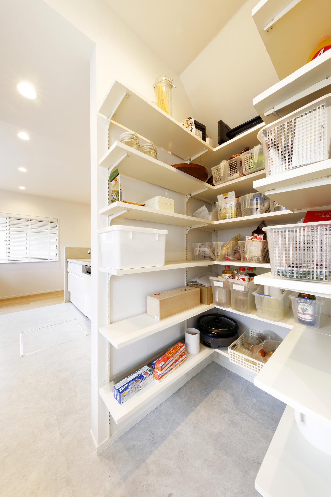 スッキリと美しいキッチンをサポートするのは、バックヤード。置いたり、並べたり、自由自在に収納OK。天井まで棚を設けて、大容量のパントリーをつくった。