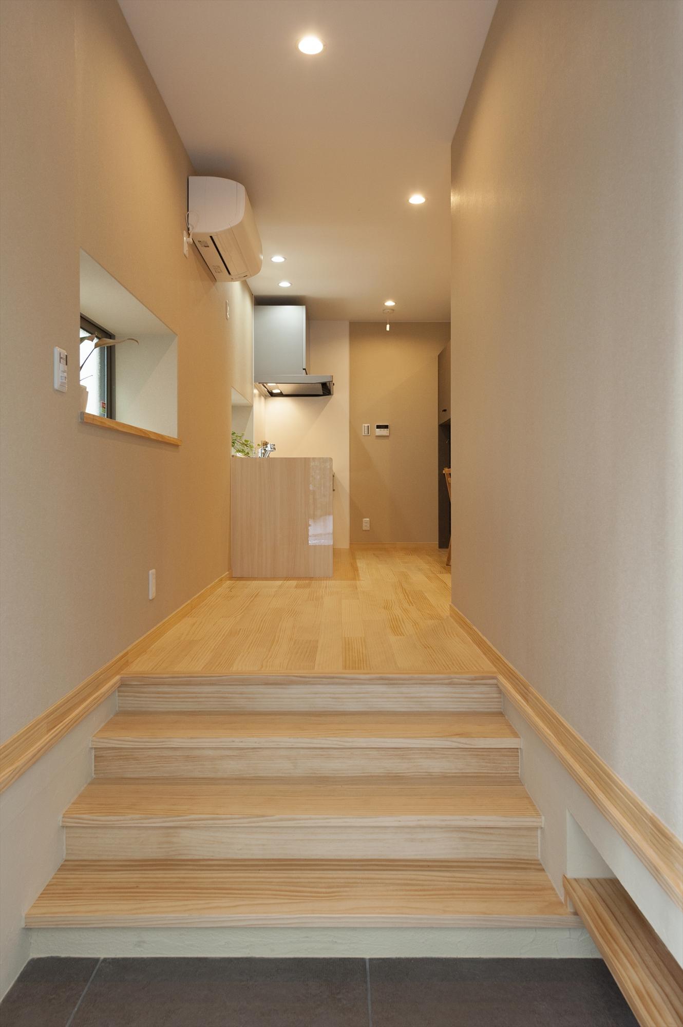 玄関は広げて、開放感のある土間風に。そのままLDKへとつながる動線にして、緩やかな段差のステップをつけて