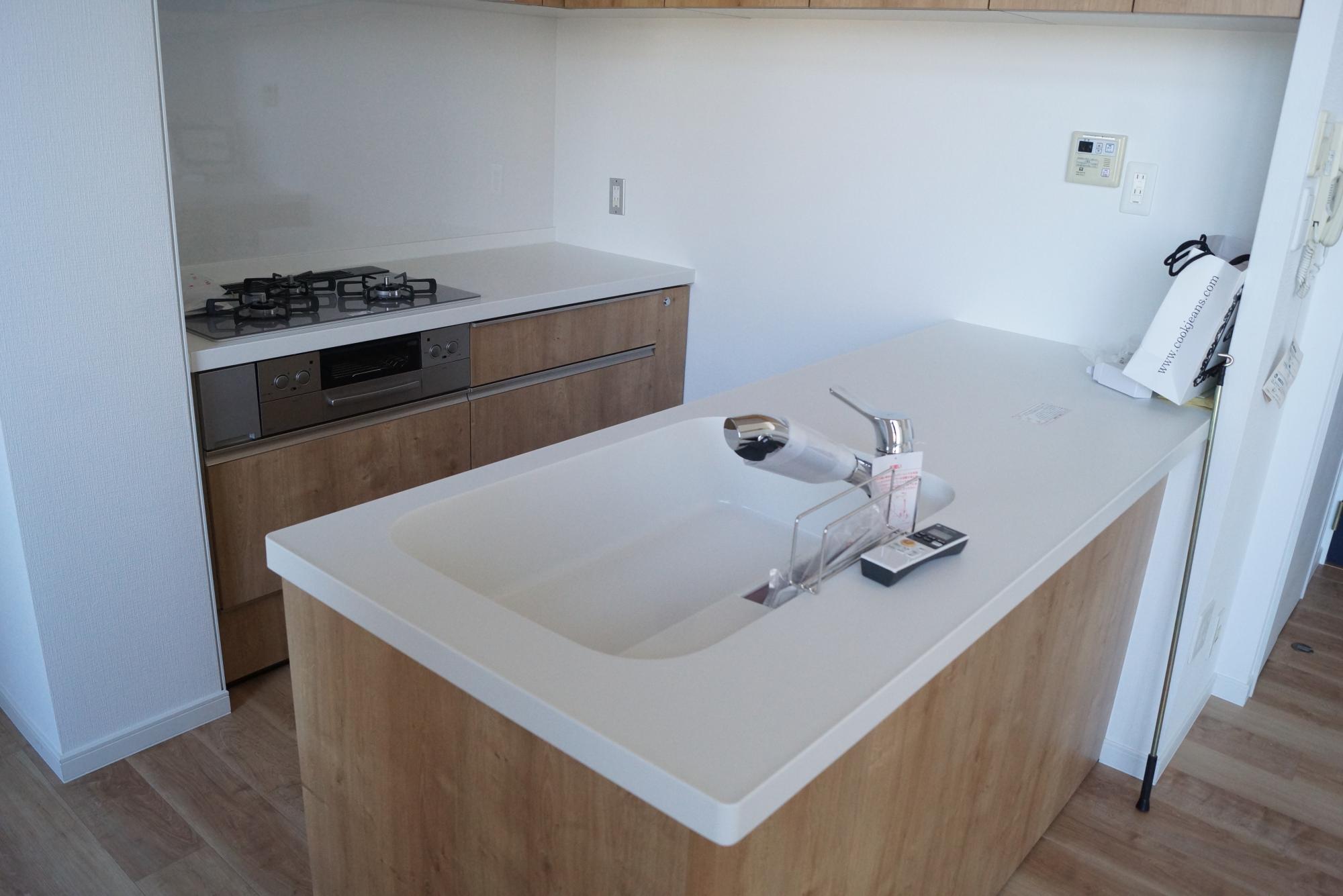 「眺望と風通しを活かした、スタイリッシュでシンプルな明るい家」のキッチン