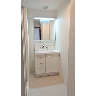 収納スペースが豊富な洗面台に入れ替え、限られたスペースでもすっきりと見せることができるようになりました。床材・壁紙の張替も行い、清潔感のある明るい空間へ生まれ変わりました。