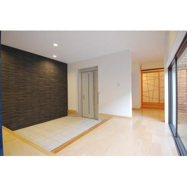 暗くて古さを感じる玄関が一転、外の光や景色を取り入れた明るくて広い玄関空間にリノベーションしました。タイルの壁が上品な空間を演出しています。