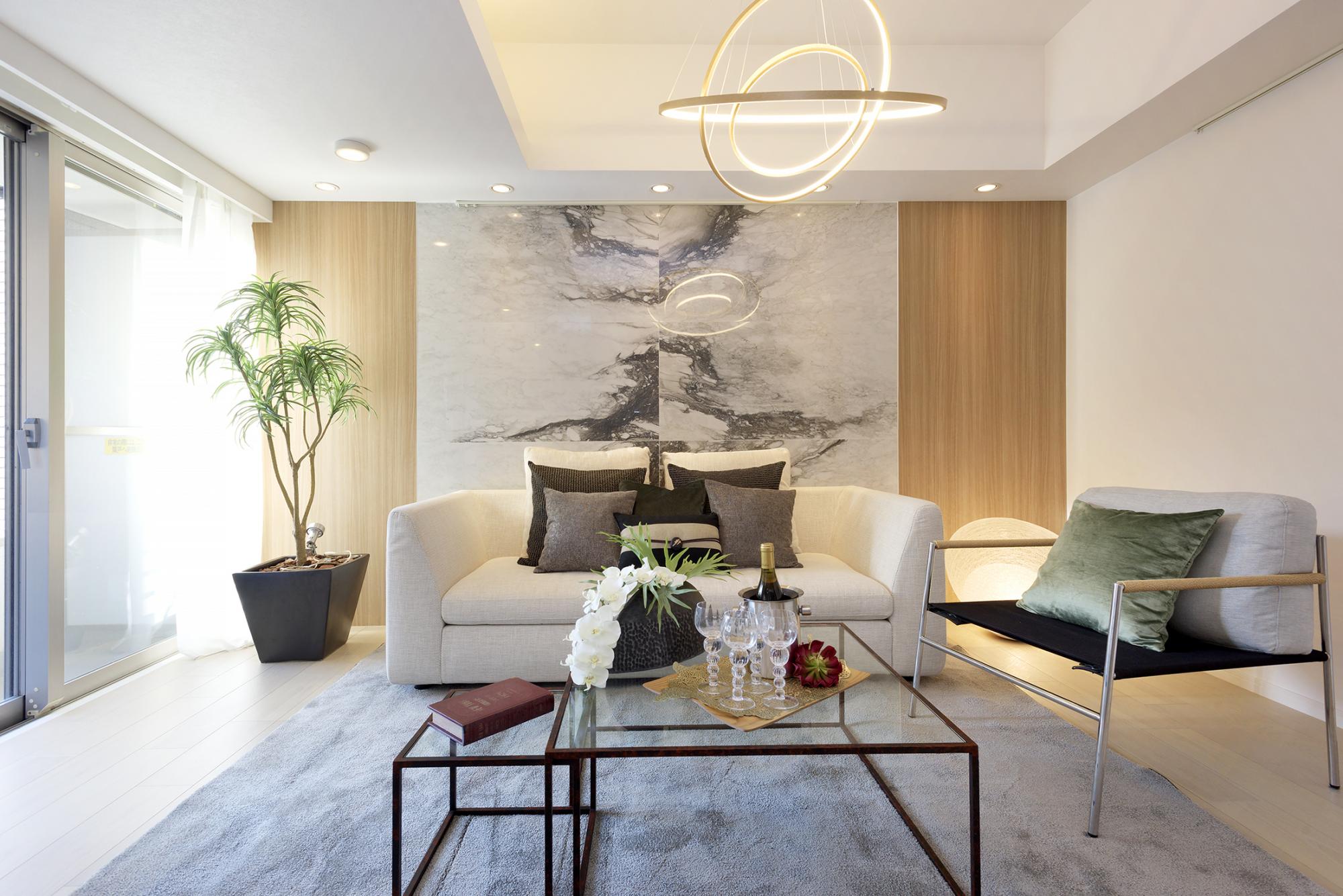 白い壁紙と淡い木目のフローリングを基調とするリビングダイニングにも、大理石調のタイルと木目のクロスがアクセントに。