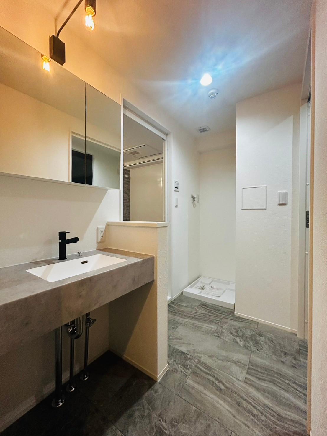 洗面脱衣所は室内洗濯機置き場に収納付きの洗面台があるシンプルながらもお洒落で使い勝手を考えられた造り。