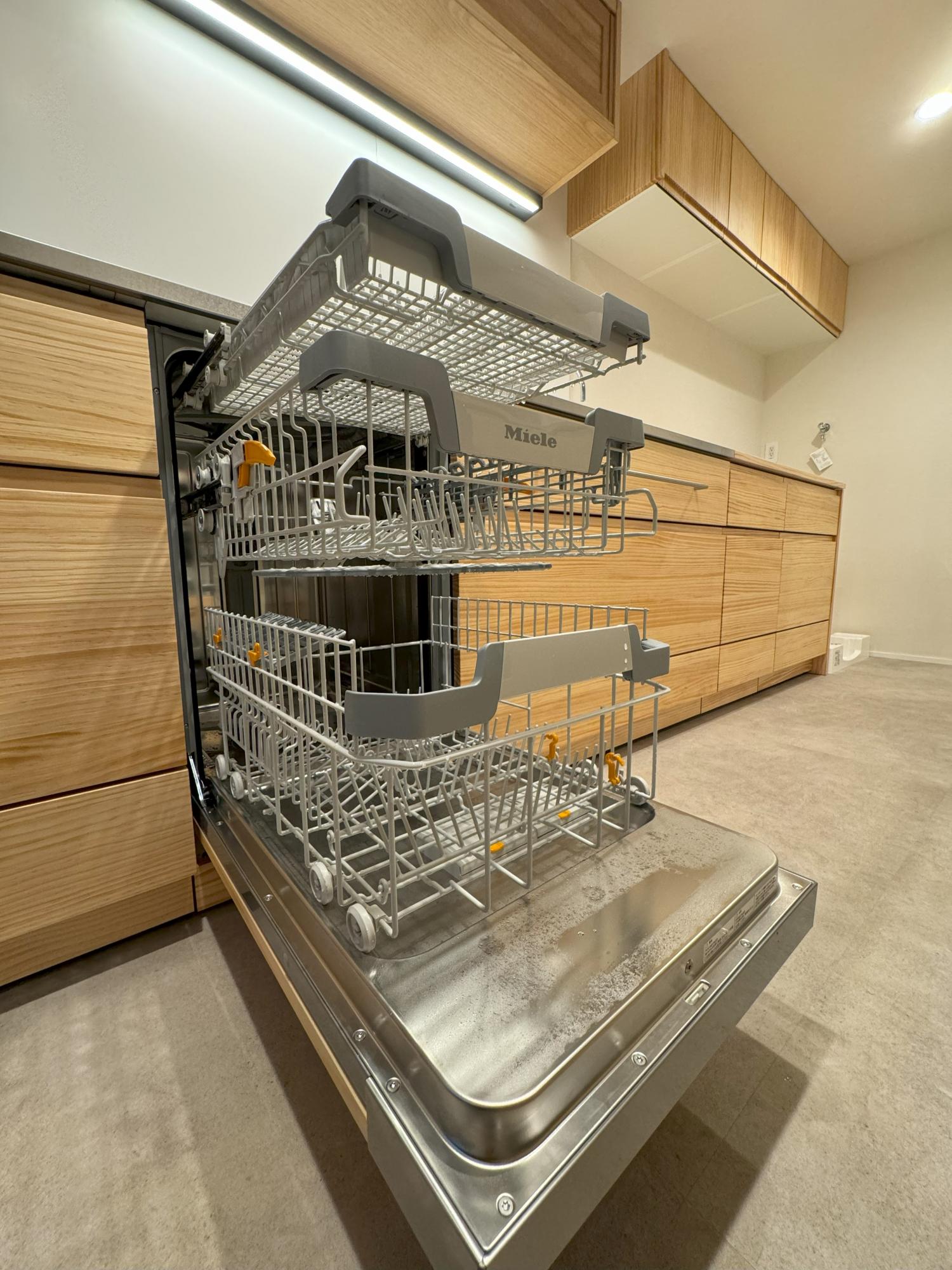 「廊下をなくして開放感あふれる住空間を実現！マホガニーの床材が美しいお住まいです。」のキッチン