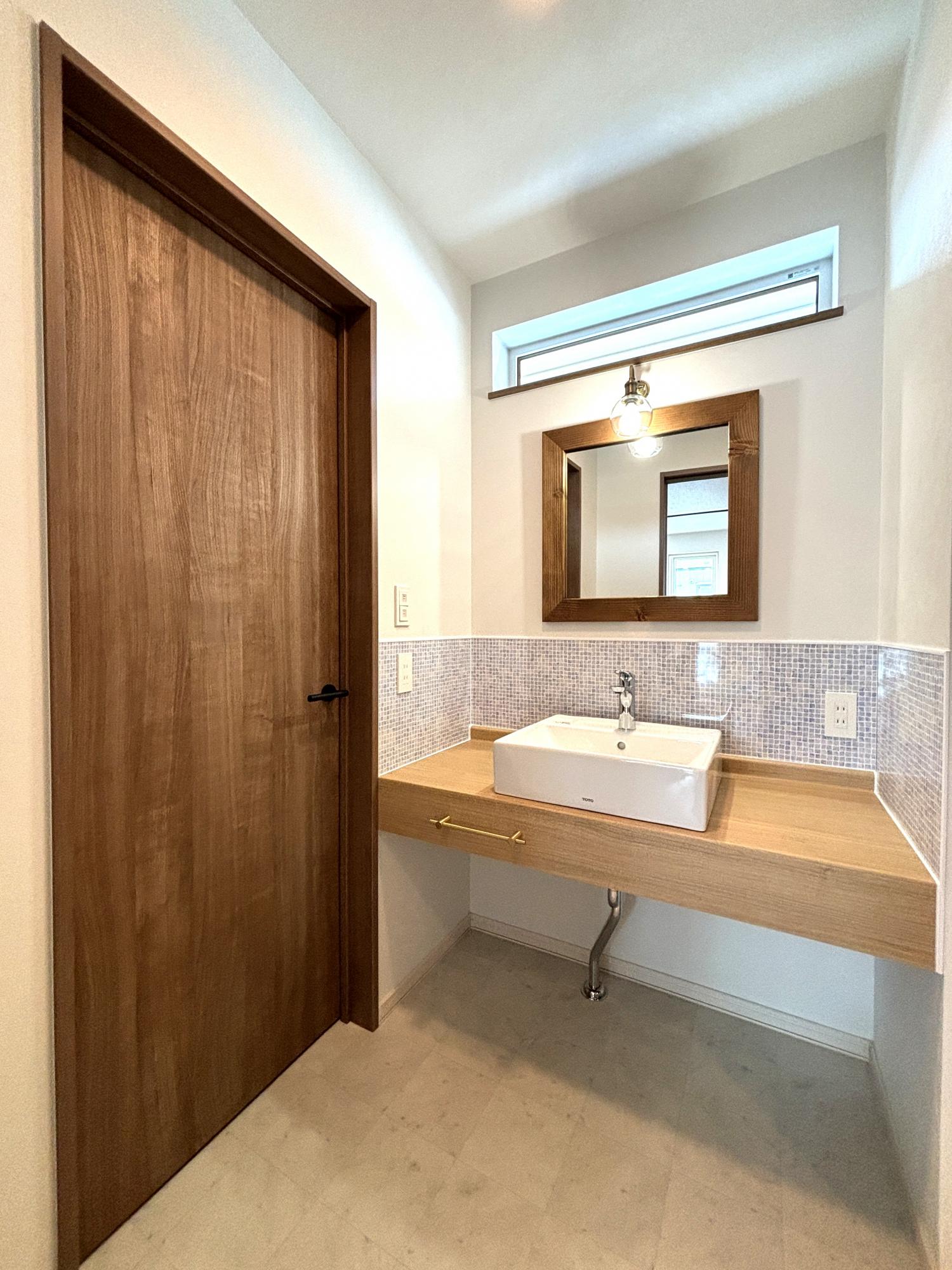 洗面室と脱衣室を分けた空間をつくりました！
洗面台は人気のアイカ造作洗面です。
鏡もアンティーク調のものをお選びいただき、アクセントにもなる水はね防止タイル調のパネル！