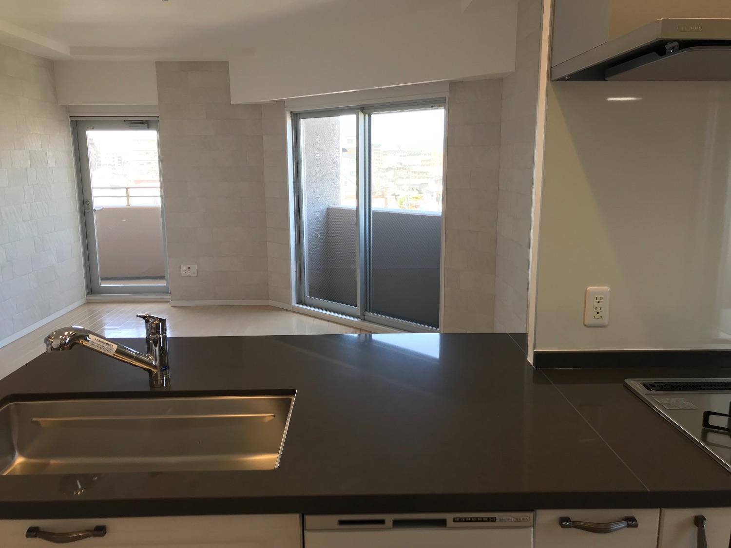 「高級感あるクオーツストーンのグレー天板のキッチンとブルーグレーの明るいお部屋」のキッチン