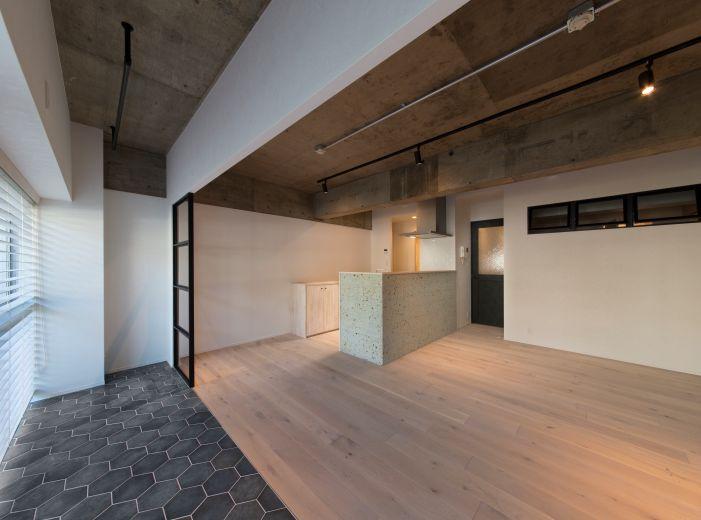 「躯体現しとアイアン調の照明で大人空間に」のリビングダイニング