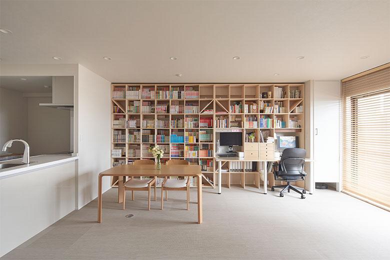 コレクションしてきたたくさんのコミックをすっきり収める壁一面の本棚は設計当初から希望。リモートワークが増えたことと、将来子どもがリビングで勉強できるようにデスクも組み込んである。