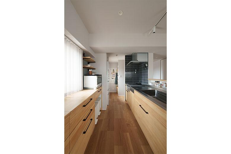 背面には大容量のカップボードがならび、カウンターキッチンの壁にはスパイス用のニッチを。キッチン奥にはパントリーがあり、片付くキッチンとなった。