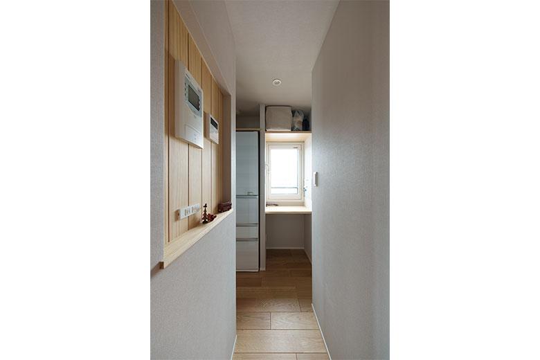 キッチンのコンロ脇に回遊動線をつくり、キッチンから洗面室へ、玄関へとスムーズな行き来ができて便利。アクセスのいい部屋の中心に位置し、ニッチを設けて各種リモコンを配置した。