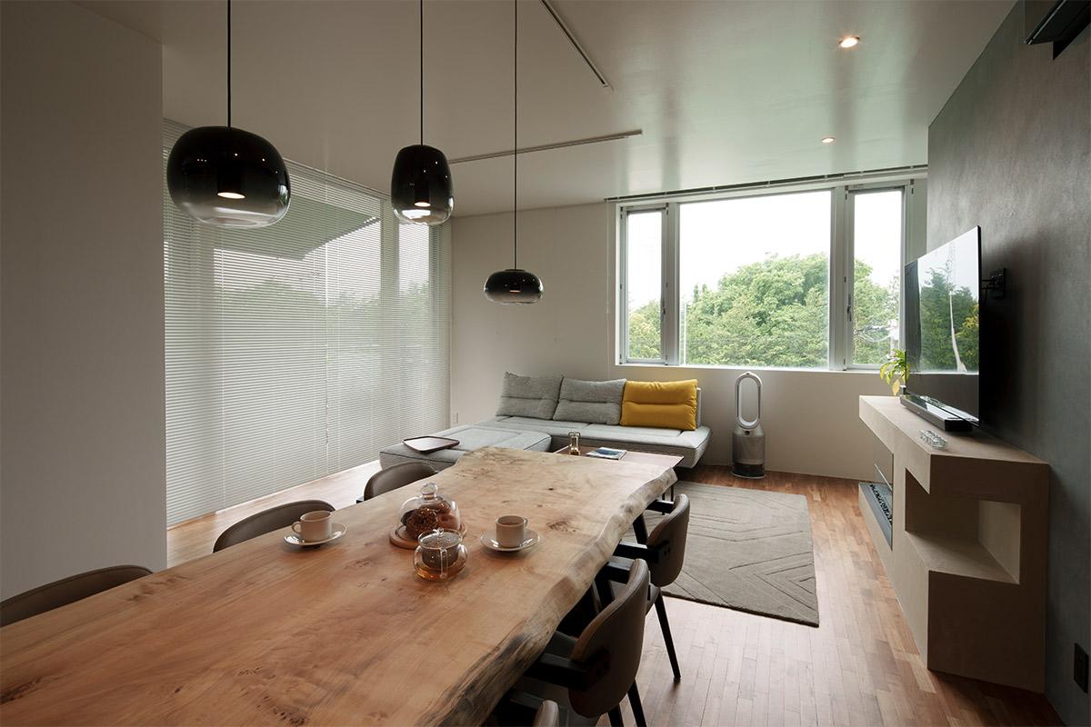 LDKから窓外の木々が見えるので、外の景色も取り込んだプランに。天井にも木々のグリーンが映り、家の中ではないようなオープンな気持ちになれるという。一枚板のダイニングテーブルとも相性が抜群。