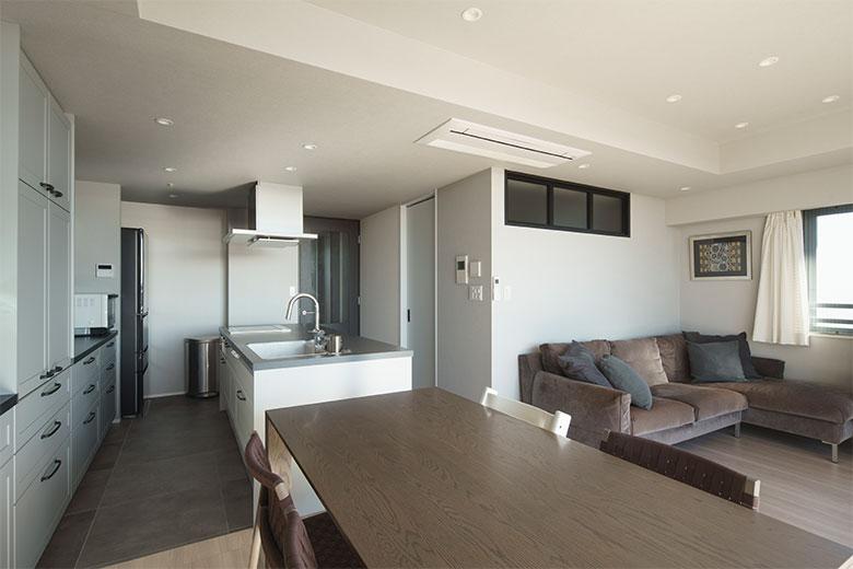 LDKのサイズは変えずに子供部屋を増やしたいとご希望。対面式だったキッチンの向きを変えて、広くオープンなアイランド型にしたことで、さらに解放感がでて明るくなった。リビングのソファ上の室内窓がある部屋が洋室３だ。