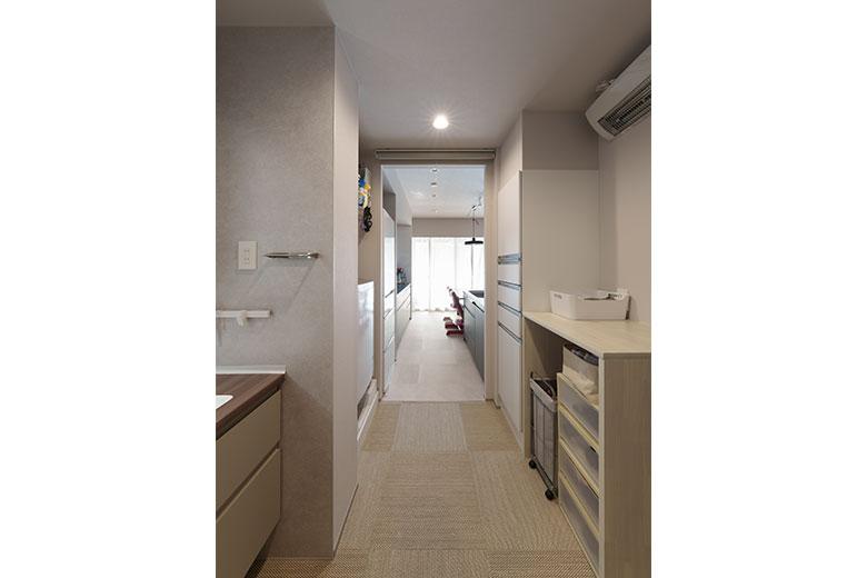 今までストレスを感じていた家事動線は、キッチンと洗面を真っ直ぐつなげることでスッキリ解決。前から扉は開けておくことが多かったので、コストを考慮してロールスクリーンで隠せるようにした。洗面・脱衣の床は温浴施設で気に入ったフロアタイル。手入れも簡単そうなので洗面室に採用したという。