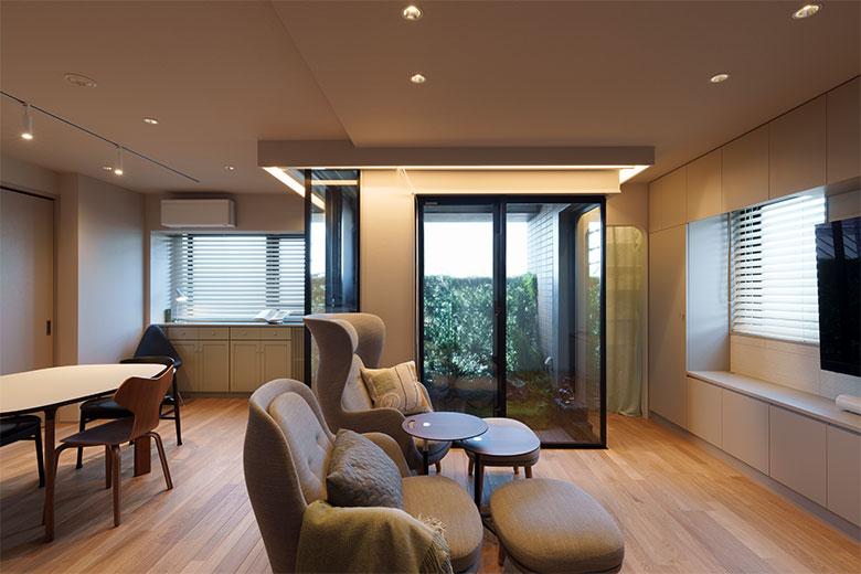 三面窓が開放感を演出するLDK。以前はリビングと個室に仕切られていたが、採光や風通しが良くて昼間もっとも過ごしやすく、窓２面を使う部屋が個室なのがもったいないと思われていた。そこで、フェイクグリーンをDIYしたベランダも含めてリビングに取り込み、広く気持ちいい空間にすることにした。