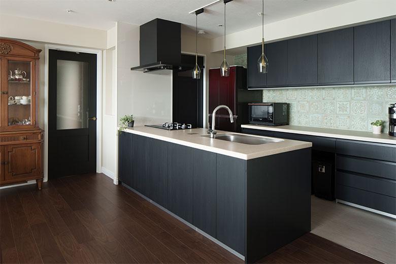 色使いにこだわり、フローリングを基準にしてキッチンの色を決めて、リビングドアやクロスを選んだそう。クールな色づかいのキッチンには、ショールームで一目惚れしたというリレーフ状の美しいグリーンのタイルを合わせた。収納はカップボードやキッチン本体以外に、パントリーもあるので大容量でスッキリ片付く。