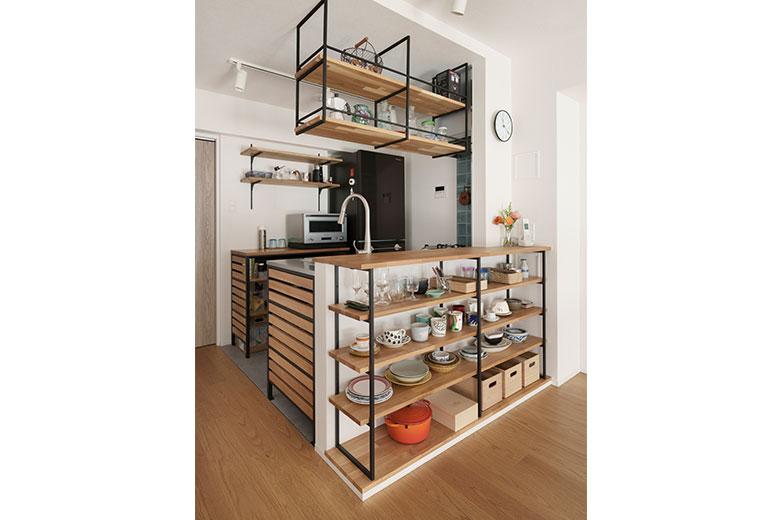 コンパクトなキッチンスペースだが、抜け感のある木目キッチンに通路幅があるので狭さを感じない。合わせて造作した吊り棚も美しく、お気に入りだという