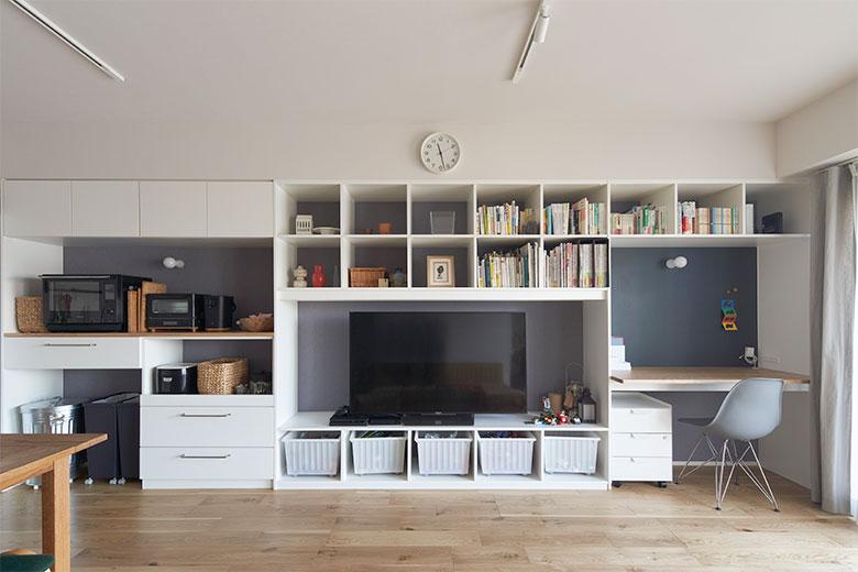 リビングダイニングを少しでも広くするために、収納は壁面を大活用した。家電やごみ箱などのキッチン収納の隣に、テレビ台や本棚のリビング収納、そしてワークスペースと壁一面で３つの用途に分かれている。テレビの下はおもちゃ収納にして、お子様が自然とお片付けできるようにした。