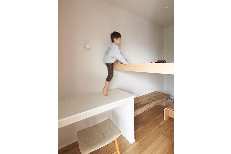 ワークスペースの背面に、デスクと本棚、ロフトベッドを造作した子ども室。コンパクトだがリビングとつながっているので狭さは感じない。「将来はリビングダイニングで勉強をさせるつもりなので、広さはこのくらいで十分。受験などで個室が必要になったら、ここを夫婦の寝室として二段ベッドのように使うつもりです」