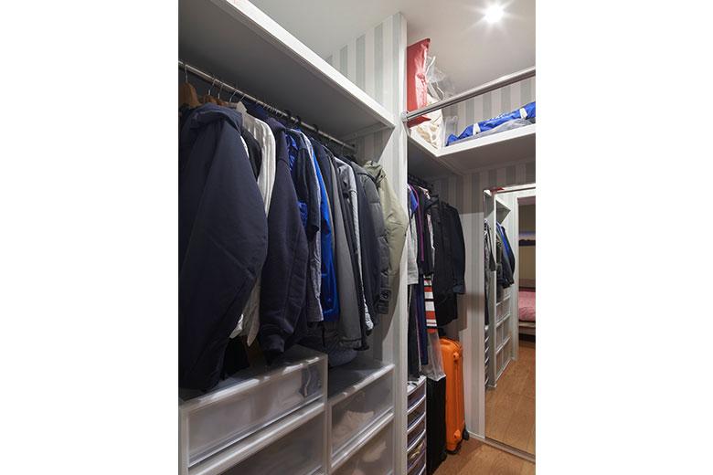小さな収納が点在していたが、寝室に洋服や布団をまとめて収められる大容量のウォークインクローゼットを新設。突き当りに姿見を取り付け、ここで着替えまで完結できる。中央のハンガーパイプは、帰宅後のコートなどを一旦風通しするのに便利だとか。建築士の提案でワークスペースとの壁の上部を開けたため、通気面も安心。