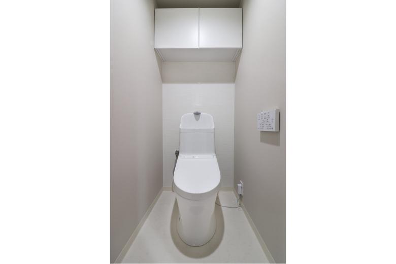 トイレにはウォシュレットを採用。吊戸棚を設置し、掃除道具やトイレットペーパーなどもすっきり収納できるスペースを確保しました。