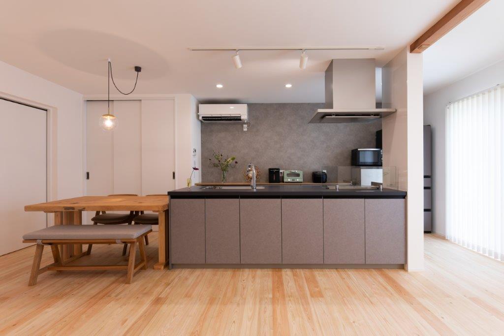 シンプルで洗練されたデザインが魅力のキッチンダイニング。落ち着いた色合いのキッチンと木の床が調和し、上質で心地よい暮らしを演出します。