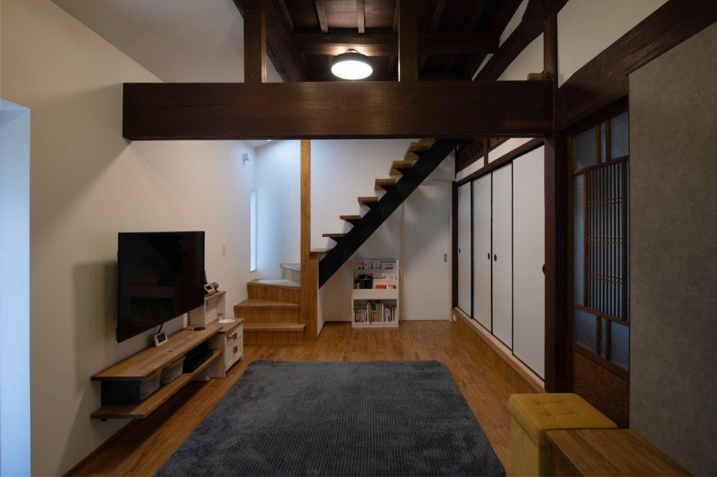 重厚な梁と現代的なデザインが調和した、落ち着きのあるリビング空間。開放感のある階段とすっきりとした動線が、心地よく整った暮らしを演出します。