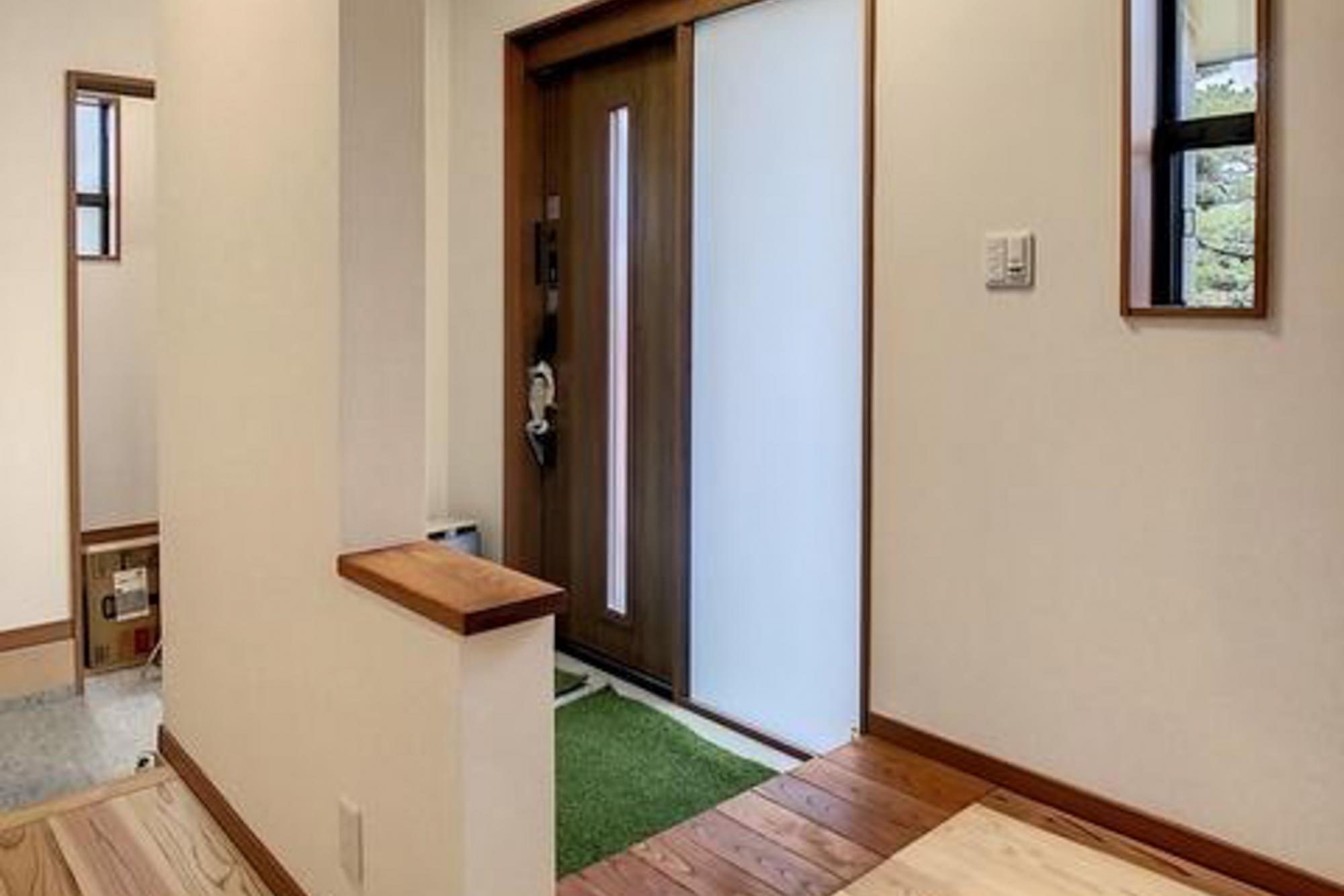 元の家の居間部分に移設した玄関。シューズクローゼットを備えたことで収納力が大幅にアップ。プライベート用と来客用に分け、来客側の上がり框には既存で使用していた欅の板を再利用。これからの生活を考え、段差を低く設計し、安心安全にも配慮。