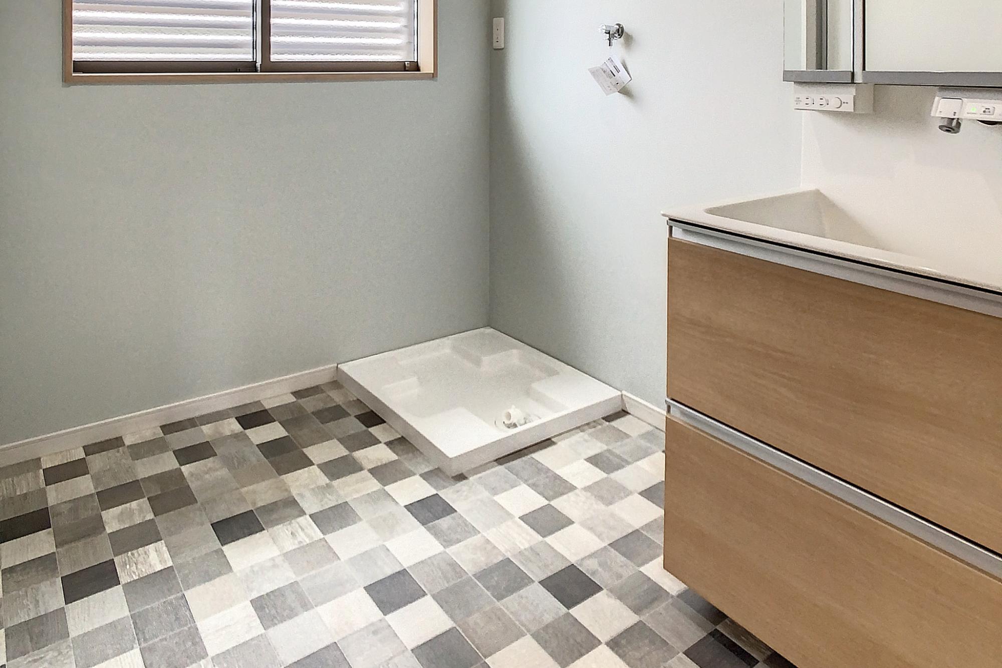 フロアと壁の色を調和させ、おしゃれで落ち着いた雰囲気に仕上げた洗面脱衣室