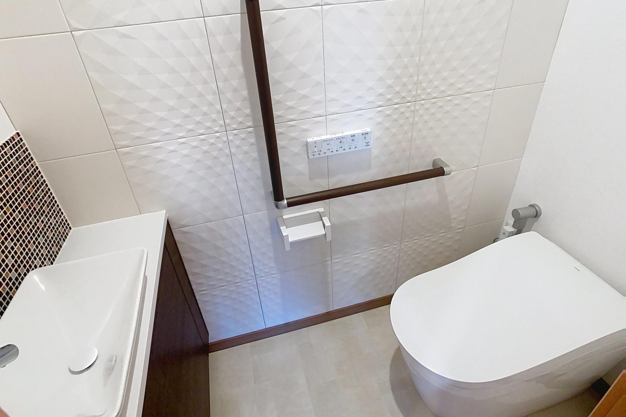 全体的にグレードアップしたトイレ。
便器・手洗い器（下部収納付）交換、既存エコカラットタイル貼替。
天井壁ビニールクロス・床クッションフロア張り替え・機能満載便器に交換・便器前に自動水栓敷手洗器(下部収納付）に交換